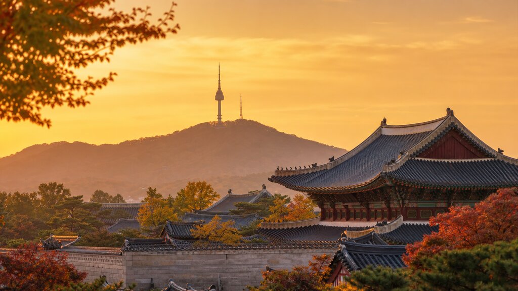 Warm golden-hour view of a Seoul palace with Namsan Tower in the distance welcoming first-time visitors