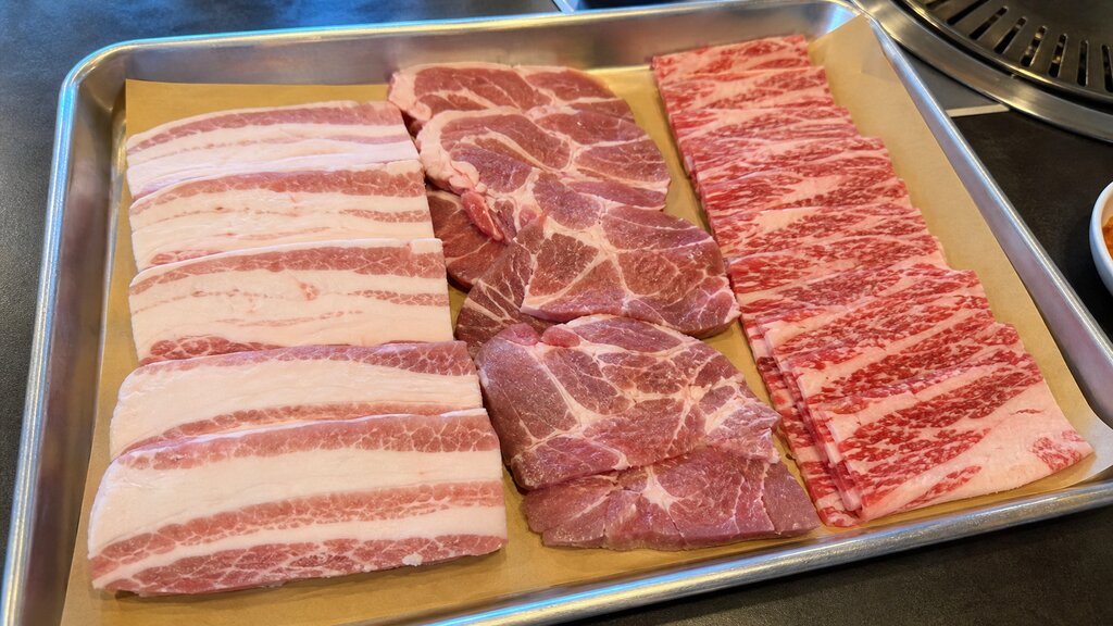 Tray of raw pork and beef cuts prepared for Korean BBQ at a Seoul restaurant