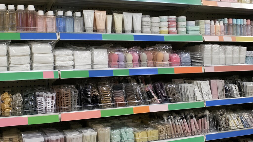 A budget variety-store beauty aisle stacked with small inexpensive skincare and tool items under simple colored shelf tags marking price tiers